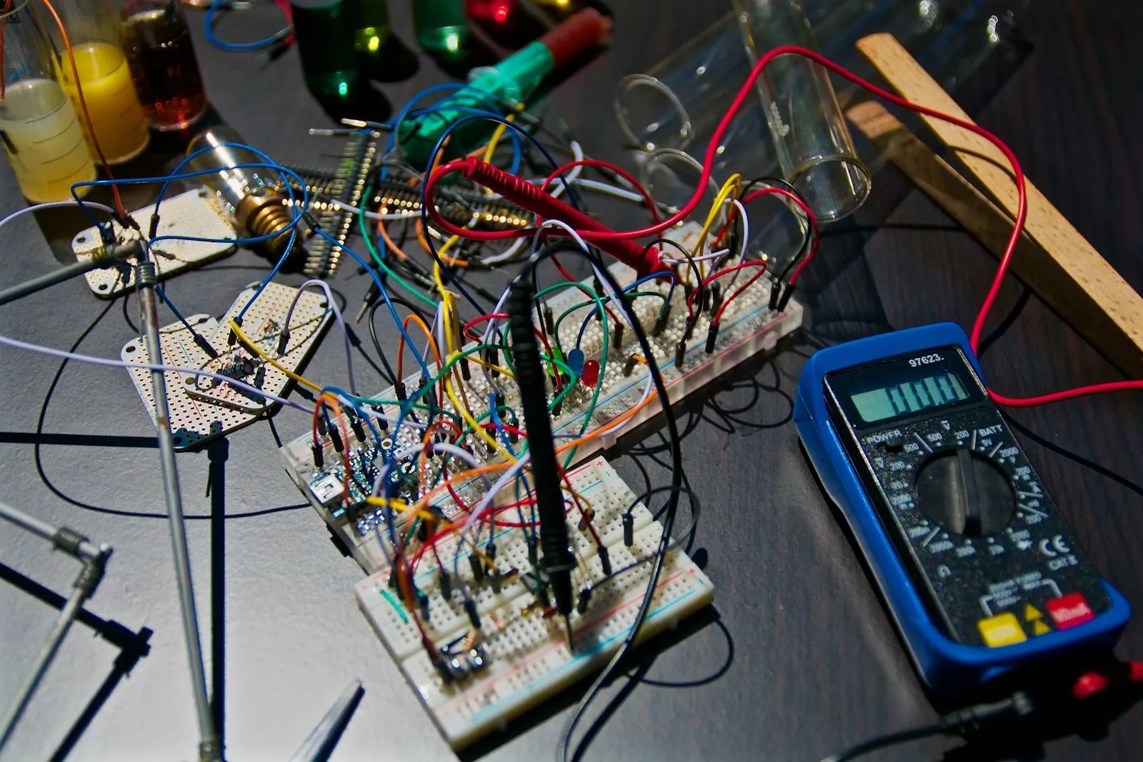 Breadboard prototype circuits under test with probes, jumper wires and a digital multimeter